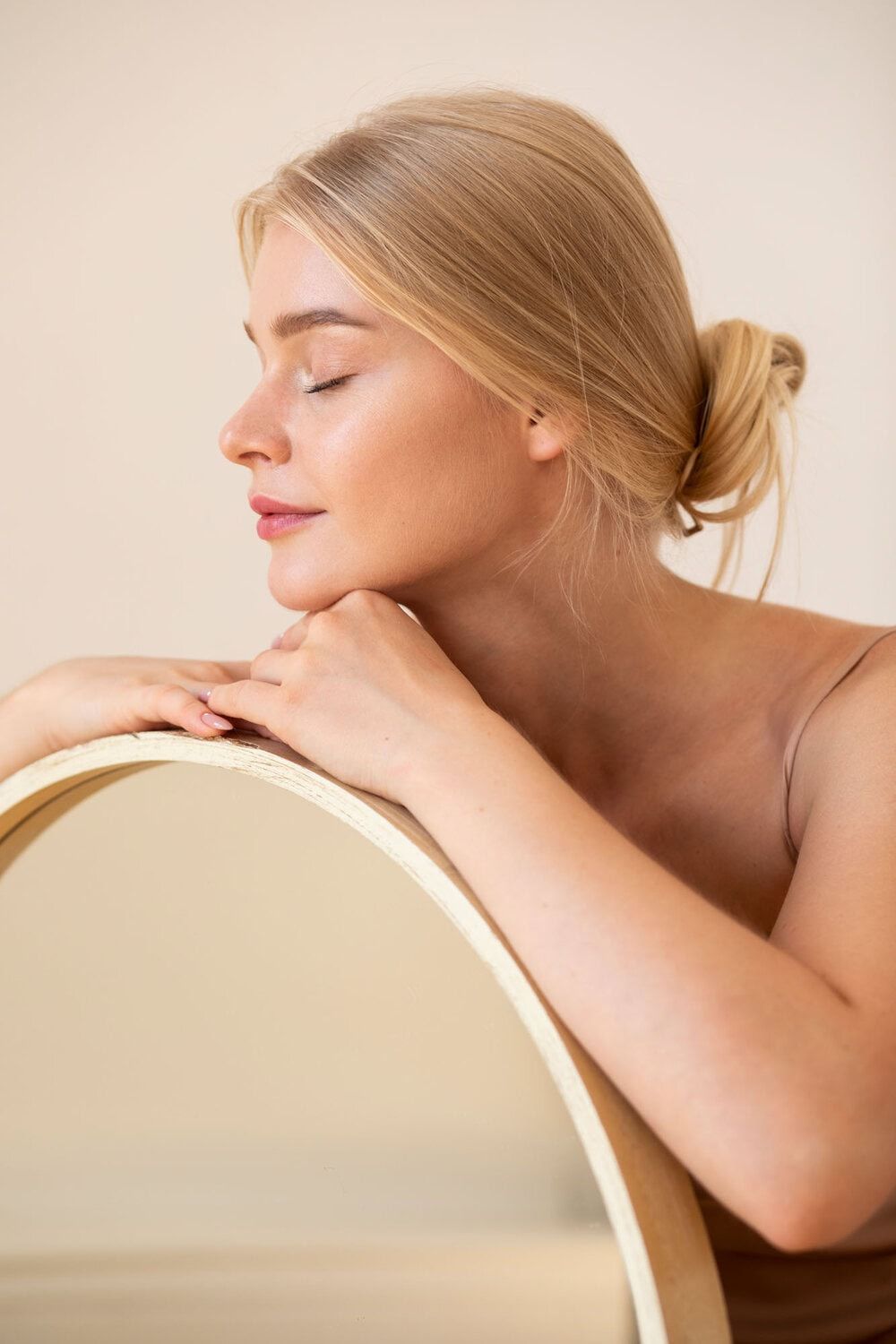 Zweedse vrouw met gesloten ogen, glimlachend, relaxte huid, schoonheidssalon, natuurlijke gloed, huidverbetering.
