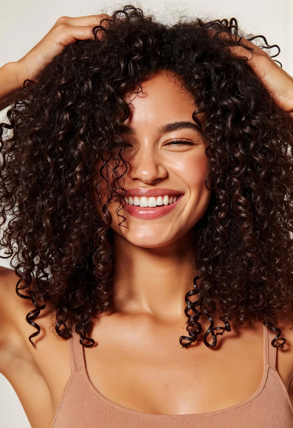 Gladde, gezonde krullende haarlook met stralende glimlach en natuurlijke huid. Perfect voor een complete huid- en haarverzorgingsroutine.