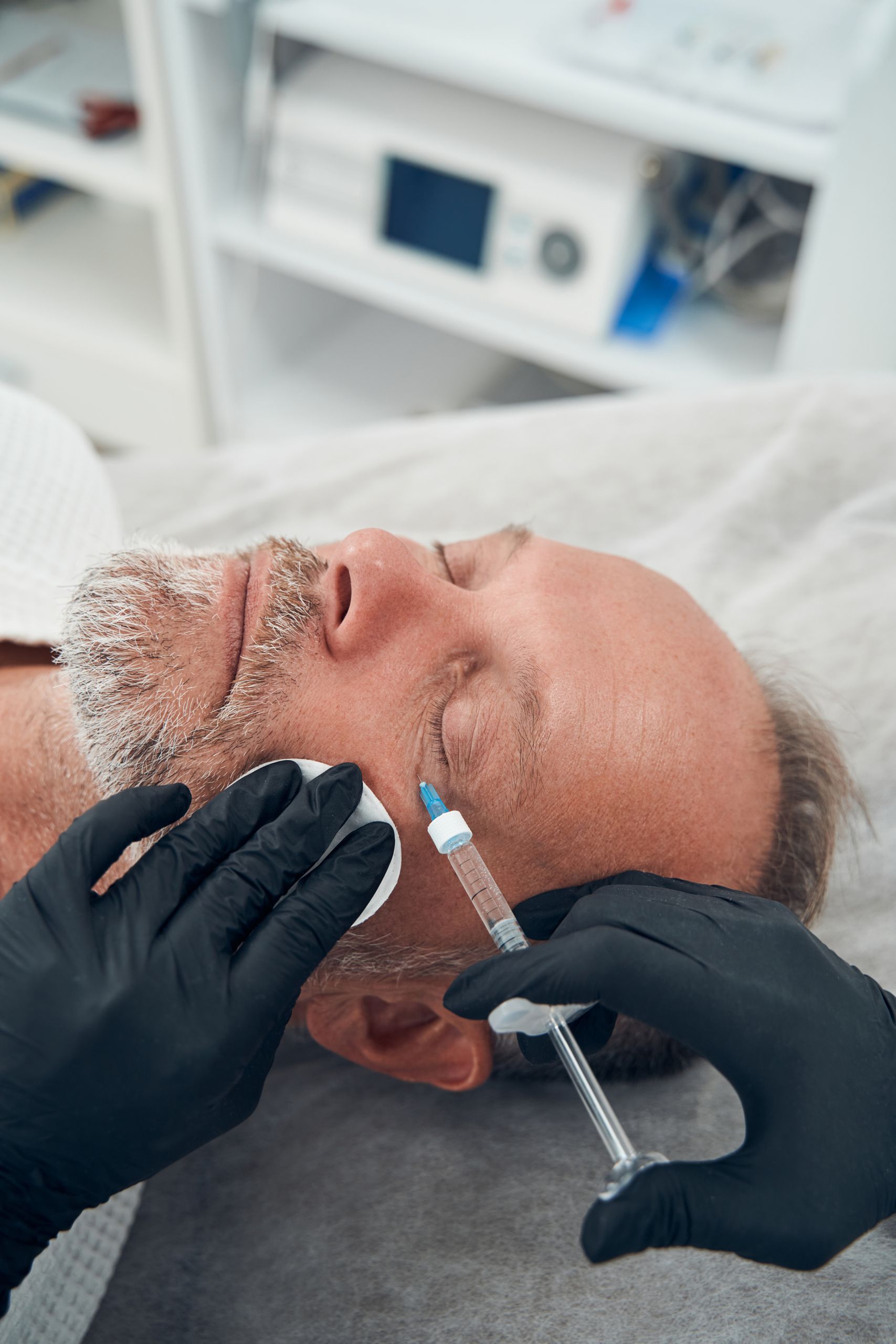 man having anti aging injection procedure in cosmetology clinic