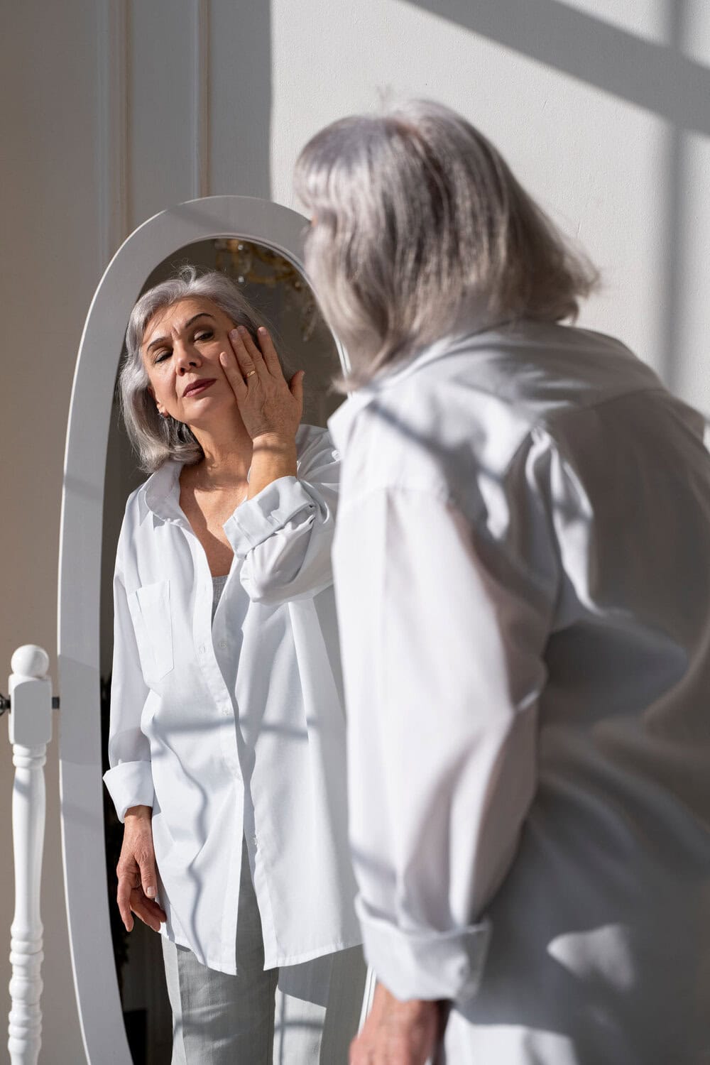 Vrouwe die haar huid onderzoekt met spiegel voor een huidanalyse, dermatologie en huidverzorging.