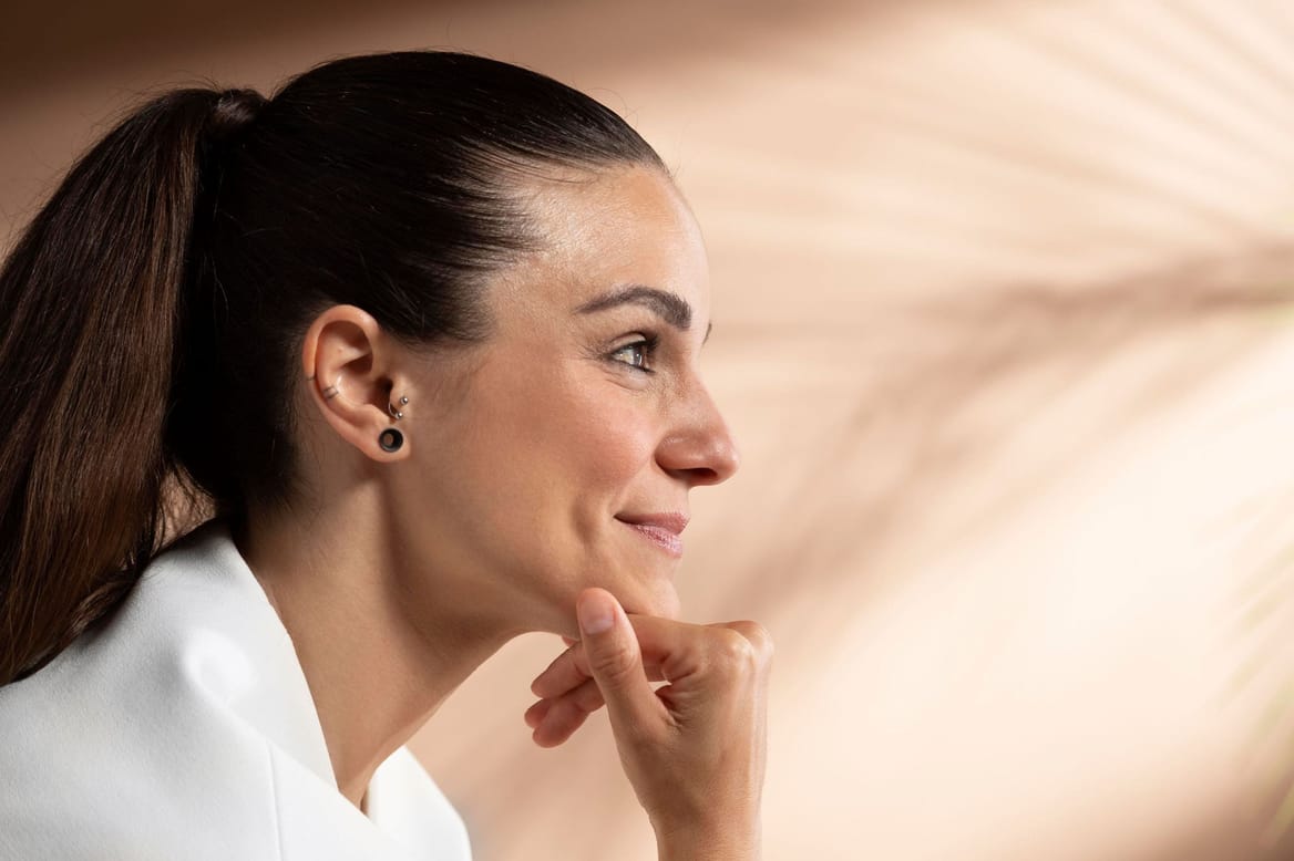 Stralende vrouw tijdens huidverbetering behandeling bij Glow Clinic in Nederland.
